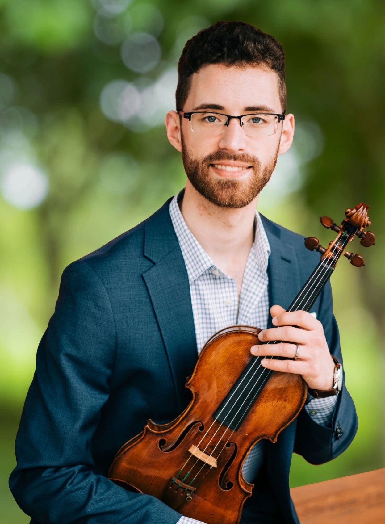 Paul Smiling in front of Greenery with Violin in hand